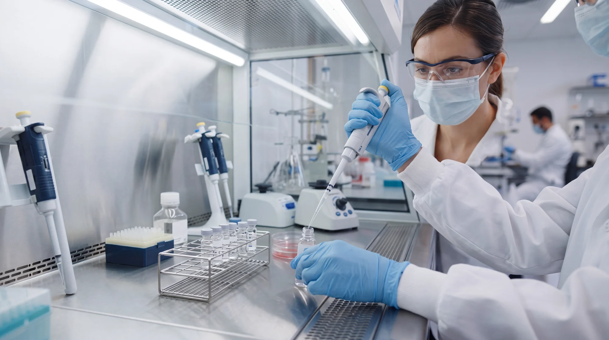 A technician pipetting samples into a rack for third-party purity and endotoxin testing.